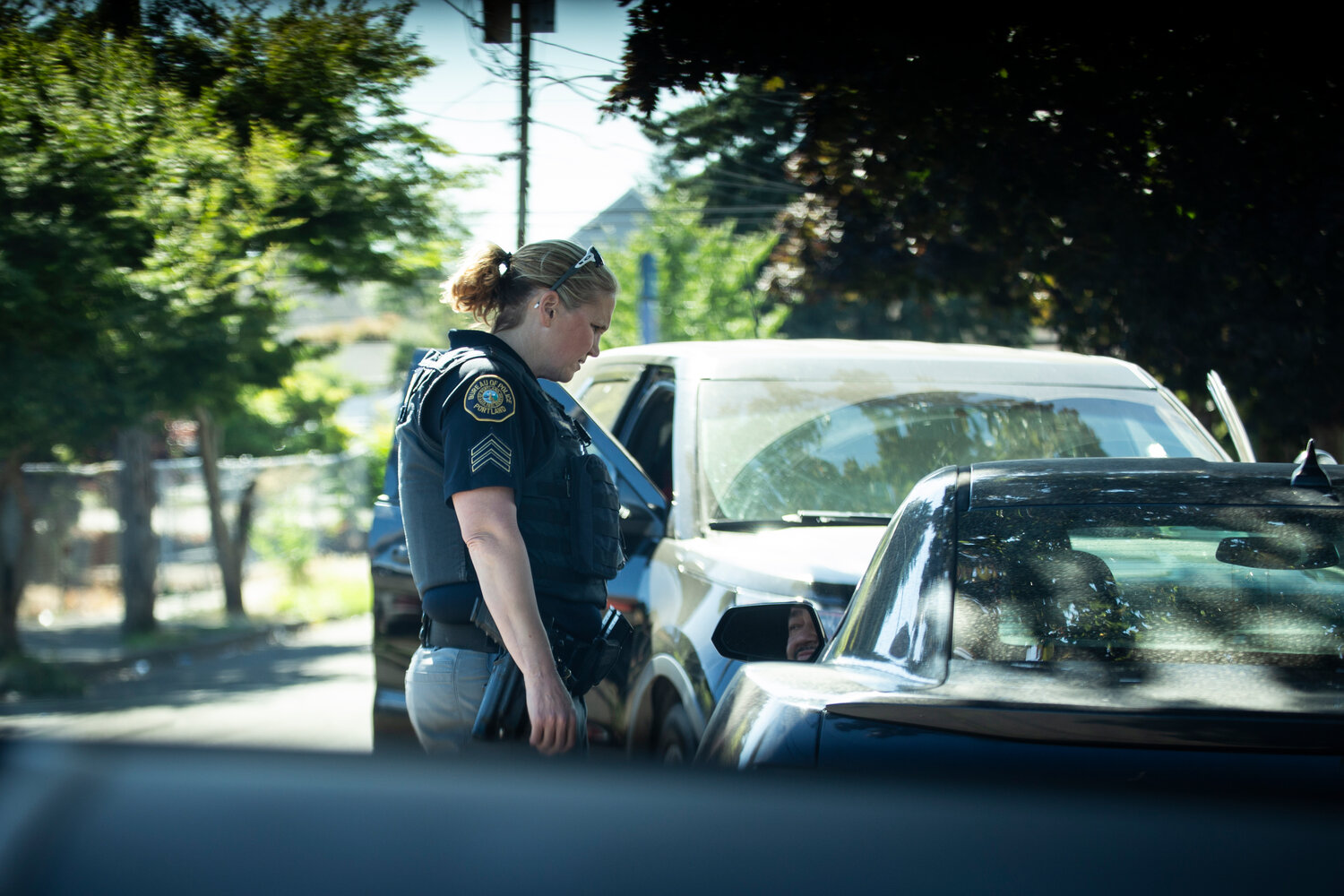 Police Sgt. Kristi Butcher, supervisor of the Portland Police Bureau’s Human Trafficking Unit, interrupts a “car date” during a directed patrol mission in Northeast Portland in July. (Moriah Ratner/InvestigateWest)